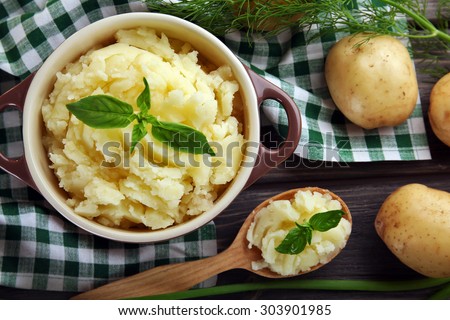 Mashed potatoes in bowl on wooden table with checkered napkin, top view Royalty-Free Stock Photo #303901985