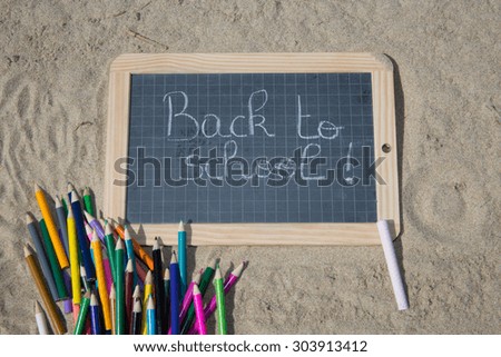 Back to school sign on the beach sand