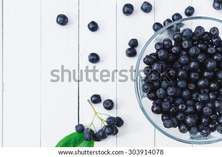Fresh Chokeberries in a small bowl. Top View Royalty-Free Stock Photo #303914078