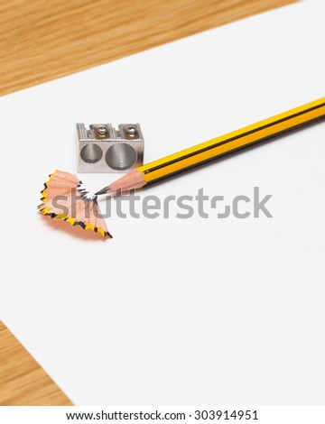 Pencil and pencil sharperner on white paper background