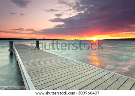 wooden jetty at lake, photographed in the evening, sunset in summer 