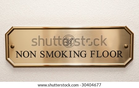 Shiny brass plate restricting smoking on hotel floor