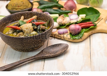 Delicious local Thai cuisine of green curry chicken soup with spicy herb on wooden cutting board for serving