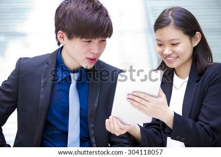 Young Asian business executives in discussion using tablet PC