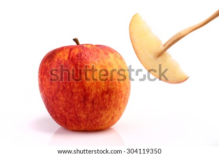 Cool red apple on fork isolated on white background.