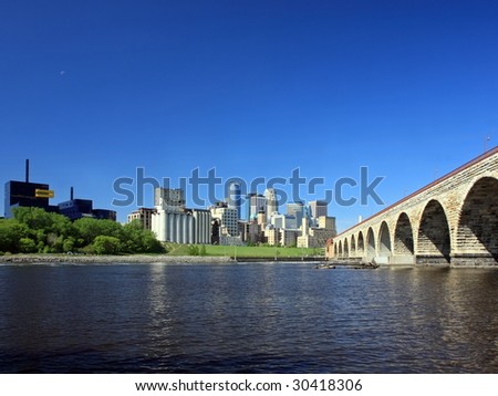 Downtown Minneapolis and Stone Arch bridge over Mississippi river