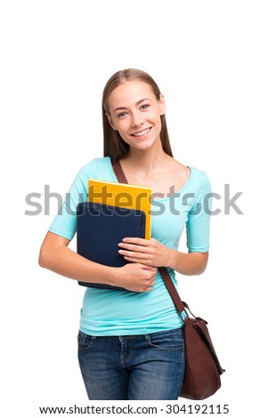 Young student girl smiling, looking at camera and holding books. Isolated on white background