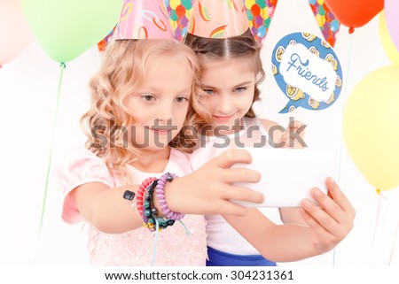 Friends forever. Two pretty joyful girls doing selfie during birthday party.