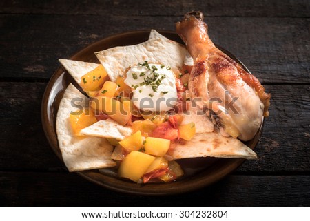 Served chicken drumstick and tortilla bread on wooden background 