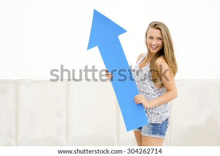 Young and beautiful girl  holding a blue arrow 