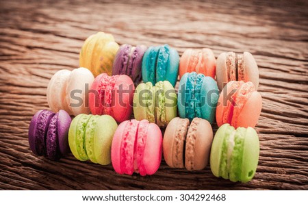 Soft focus of colorful macarons on the wooden background with vintage style
