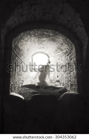 Headless ghost trying to get away from the light in medieval castle.