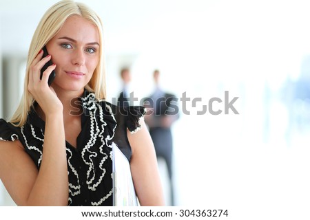 Portrait of pretty beautiful business woman on the phone with a modern building 