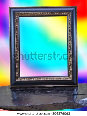 Vintage picture frame on wood and on colorful background.