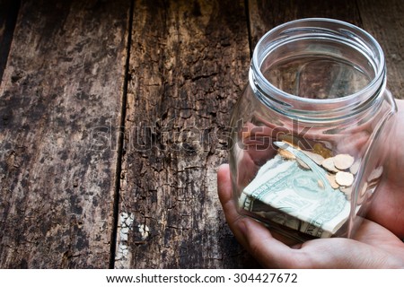 man holding a glass jar for donations Royalty-Free Stock Photo #304427672