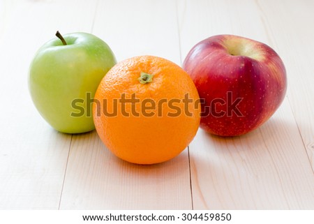 Apple and orange fruit on wooden background
