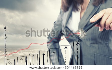 Close up of businesswoman drawing increasing graph with marker