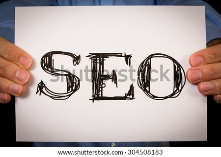 Studio shot of man holding white sign with the word SEO