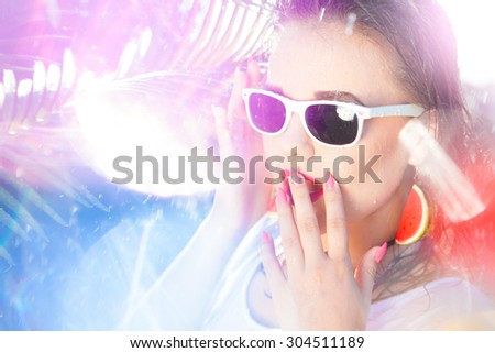 Colorful summer portrait of surprised young attractive woman wearing sunglasses and watermelon earrings, beauty and fashion concept natural bokeh and light effect