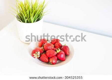 A plate of strawberries in white interior