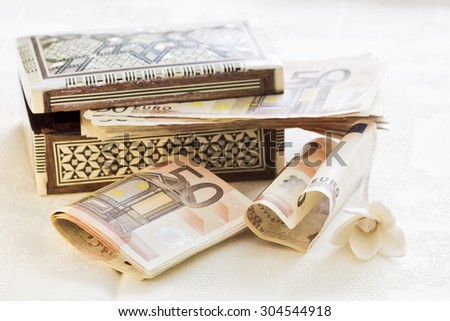 Fifty euro banknotes, gift box and flower