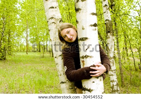 Beautiful girl hugs a treen