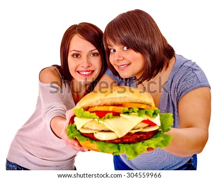 Women giving hamburger in camera . Fast food in our lives