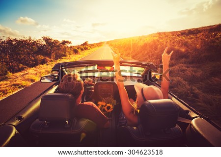 Happy Young Couple Driving Along Country Road in Convertible at Sunset. Freedom Adventure Road Trip Royalty-Free Stock Photo #304623518