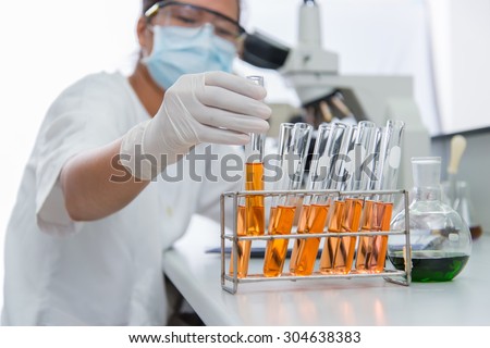 Closeup hand, young scientist in labcoat wearing nitrile gloves, doing experiments on white background. Royalty-Free Stock Photo #304638383