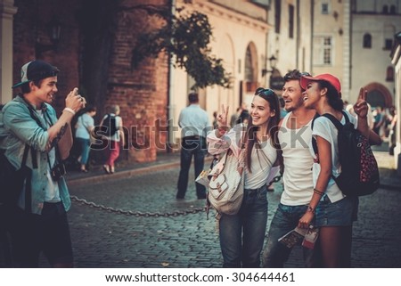 Multiracial friends tourists taking picture in an old city 