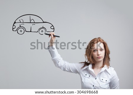 Young woman drawing car, concept on the subject of dreams or financial planning