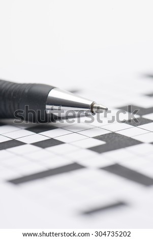 Closeup of crossword puzzle and pen. Conceptual image of problem solving, finding solutions and intelligence.