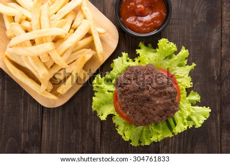 hamburger with french fries on wooden background.