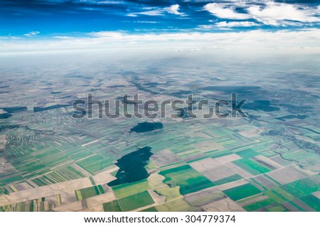 Cloudy sky over the land, image taken from the airplane window