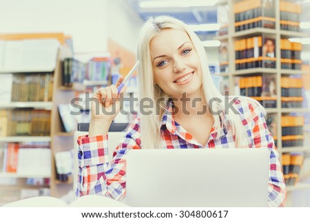 Young pretty woman studying in library