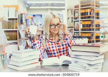 Young pretty woman studying in library