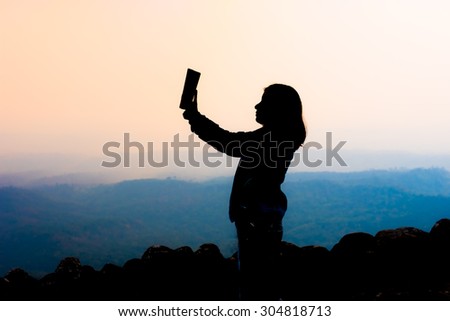 young woman selfie during Sunset on mountain with landscape view
