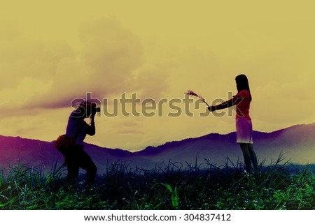 Photographers shooting a woman on mountain in vintage filter effect
