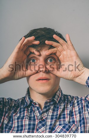 man makes binoculars hands