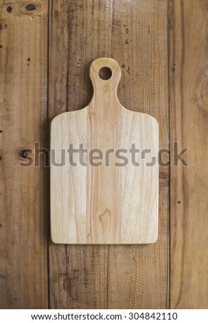 Wooden chop board on rustic wooden table top. Top view. Royalty-Free Stock Photo #304842110