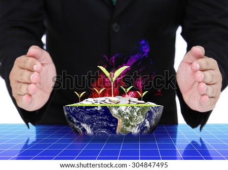 Business man hands with plant growing out of coins on earth. (Elements of this image furnished by NASA)