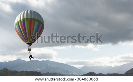 Businessman flying in search of ideas hanging on balloon