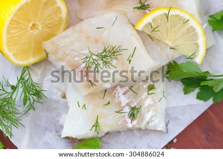 Raw fish with vegetables, lemon and seasonings on the wooden table