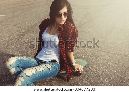 Young Attractive Girl Posing With Skate On Ground. Vintage Effect Fashion Sports Style Photo