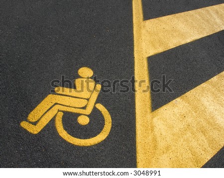 Yellow disabled parking on dark asphalt with marked area