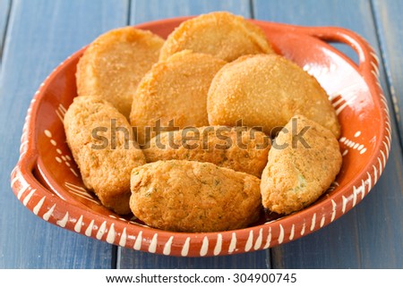 meat and cod fish croquete on dish on blue background