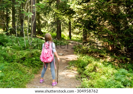 Little hiker girl in forest. Photo from Champex-Lac, Valais, swiss Alps, back view