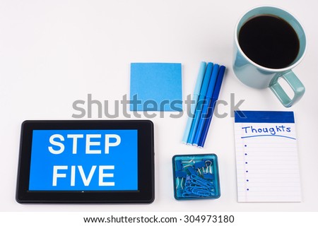Business Term / Business Phrase on Tablet PC - Blues, cup of coffee, Pens, paper clips Calculator with a blue note pad on White - White Word(s) on blue - Step Five
