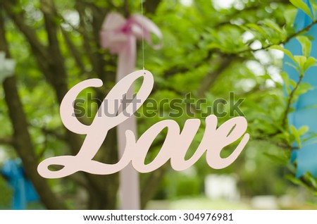 Love word hanging on string