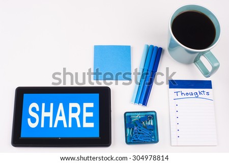 Business Term / Business Phrase on Tablet PC - Blues, cup of coffee, Pens, paper clips Calculator with a blue note pad on White - White Word(s) on blue - Share